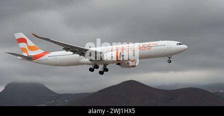 Teneriffa, Spanien 11. Februar 2024. Airbus A330-941 Sunclass Airlines fliegt in den dunklen Wolken. Landet am Flughafen Teneriffa Stockfoto