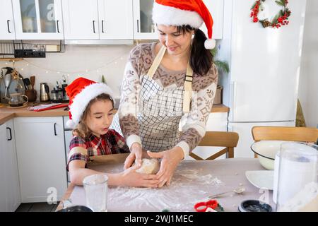 Mom und Tochter in der weißen Küche bereiten Kekse für Weihnachten und Neujahr zu. Familientag, Vorbereitung auf den Urlaub, Stockfoto