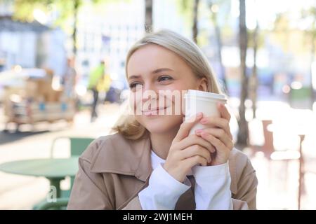 Nahaufnahme Porträt einer lächelnden, glücklichen, schönen Europäerin, die im Café sitzt und eine Tasse Kaffee genießt, ein Getränk trinkt, Enj Stockfoto