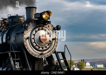 Nahaufnahme der Vorderseite einer antiken Dampflokomotive, die Rauch bläst Stockfoto