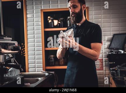 Der Barista bereitet Cappuccino auf einer Espressomaschine für den Gast im Café zu. Stockfoto