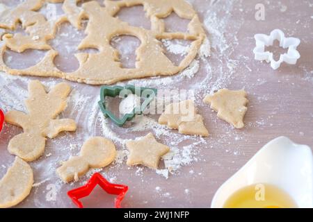 Layout der Ausstecher Close-up Ausschneiden von Keksen aus dem Teig mit Formen auf einem Weihnachtsthema in Form eines Schneemanns, eines Chr Stockfoto