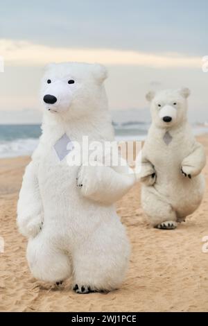 Animateure, die als Eisbären verkleidet sind, unterhalten die Leute am Strand Stockfoto