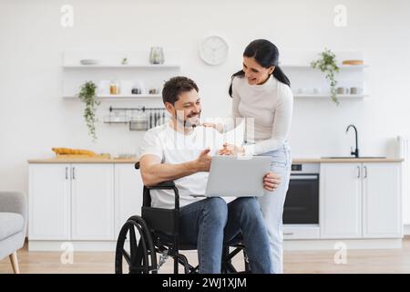Glücklicher Erwachsener, der Internetseiten surft, während er sich nach einem Unfall zu Hause erholt. Stockfoto