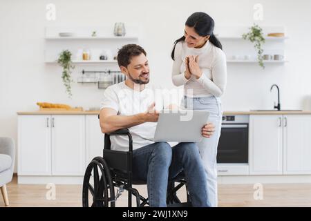 Glücklicher Erwachsener, der Internetseiten surft, während er sich nach einem Unfall zu Hause erholt. Stockfoto