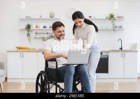 Glücklicher Erwachsener, der Internetseiten surft, während er sich nach einem Unfall zu Hause erholt. Stockfoto