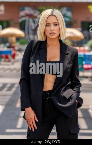 Ein schönes blondes Model posiert im Freien und genießt das Frühlingswetter Stockfoto