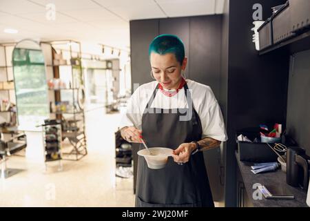 Stylist bereitet Haarfärbemittel in einem Behälter vor. Friseursalon-Konzept Stockfoto