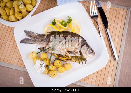 Gegrillter Karpfenfisch mit Rosmarinkartoffeln und Zitrone Stockfoto