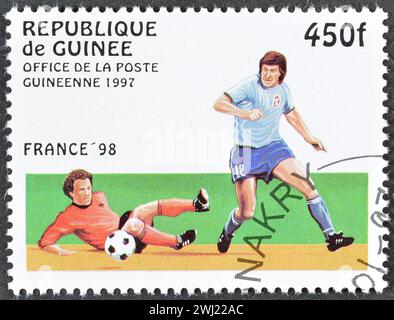 Von Guinea gedruckte Briefmarke mit Stempelabdruck, die Fußballspieler zeigt, die die FIFA-Weltmeisterschaft 98 in Frankreich um 1997 bewerben. Stockfoto