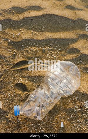 Nahaufnahme der Plastikflasche am Sandstrand. Verschmutzung von Kunststoffabfällen Stockfoto