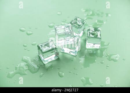 Konzept von Kälte und Erfrischung. Eiswürfel mit Wassertropfen auf grünem Hintergrund. Stockfoto