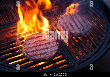 Barbecue Wagyu Beef Hamburger gegrillt aus nächster Nähe auf einem Holzkohlegrill mit Feuer und Rauch Stockfoto