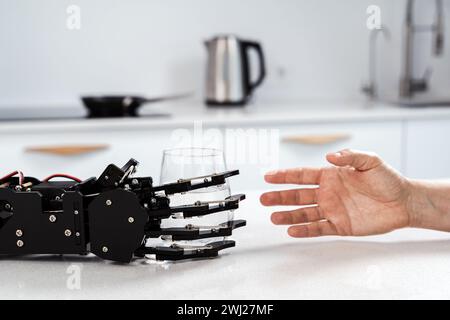 Eine robotische Pflegekraft, die eine Hand mit einem Glas Wasser auf die junge Frau ausstreckt Stockfoto