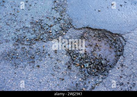 Schlagloch nach Frost auf der Straße im Frühling Stockfoto