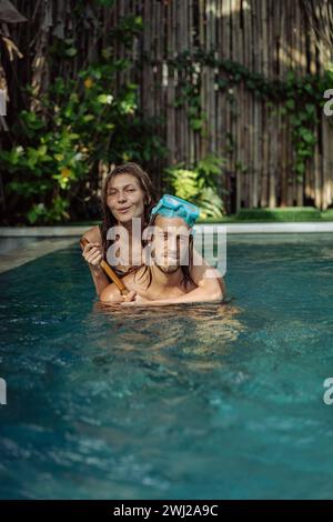 Glückliches junges Paar verliebt im Pool im Urlaub in den Tropen. Stockfoto