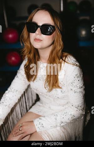 Cooles Mädchen in auffälligem Kleid und Sonnenbrille auf der Party Stockfoto