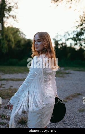 Cooles Cowgirl in der Abenddämmerung im Fransen-Partykleid im Süden von Illinois Stockfoto