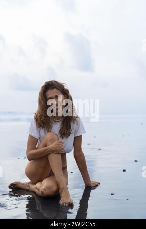 Porträt einer fröhlichen jungen Frau mit lockigen Haaren am Strand. Bali Stockfoto