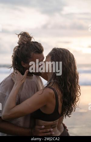 Junges fröhliches, verliebtes Paar, das sich am Strand küsst. Stockfoto