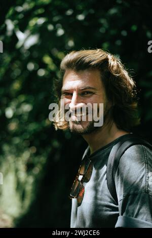 Gutaussehender, fröhlicher Mann mit langen Haaren. Stockfoto