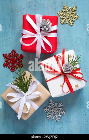 Verschiedene Weihnachtsschachteln mit Weihnachtsgeschenken, die auf blauem Hintergrund dekoriert sind Stockfoto