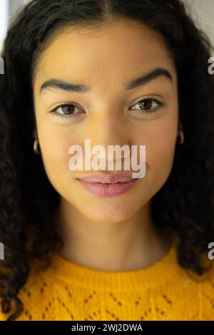 Nahporträt einer Frau mit einer Rasse in gelbem Pullover zu Hause Stockfoto