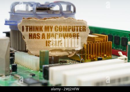 Auf der Hauptplatine des Computers befindet sich eine Pappe mit der Aufschrift. Ich glaube, mein Computer hat ein Hardwareproblem. Computerreparaturkonzept. Stockfoto