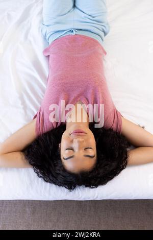 Birassische Frau schläft im Bett in sonnigem Haus Stockfoto