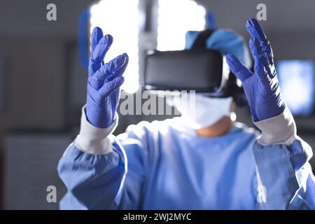 Birassische Chirurgin im OP-Kleid mit vr-Headset Stockfoto