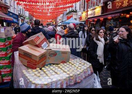 In der Gerrard Street in Chinatown werden Paletten mit Lebensmitteln behandelt, während die neu installierten roten Laternen zur Vorbereitung der chinesischen Neujahrsfeier am 9. Februar 2024 in London hängen. Chinatown ist eine ethnische Enklave an der Grenze zu Soho und befindet sich derzeit in der Gerrard Street. Es enthält eine Reihe chinesischer Restaurants, Bäckereien, Supermärkte, Souvenirläden und anderer chinesischer Unternehmen. Stockfoto