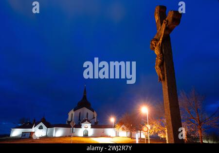 Zdar Nad Sazavou, Tschechische Republik. Februar 2024. Vor der Wallfahrtskirche St. ist ein Kreuz zu sehen Johannes von Nepomuk in Zdar nad Sazavou. Mitten im Winter wirkt die Landschaft an der Grenze zwischen Böhmen und Mähren wie Frühling. Die Anlage in Form eines fünfzackigen Sterns wurde vom Architekten Johann Blasius Santini-Aichel geschaffen und gehört heute zum UNESCO-Weltkulturerbe. Quelle: Hendrik Schmidt/dpa/Alamy Live News Stockfoto