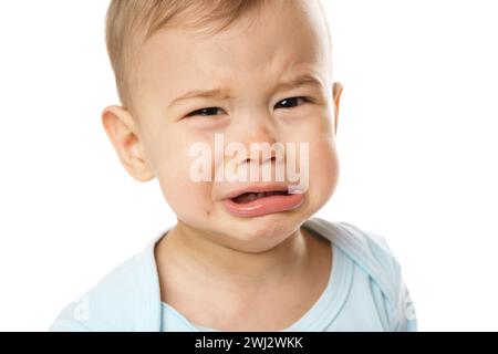 Closeuo-Schuss des Gesichts eines schreienden kleinen Jungen im Strampler. Stockfoto