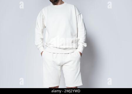 Mann mit weißem, leerem Sweatshirt und Shorts Stockfoto