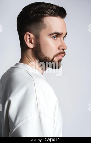 Schöner Mann mit weißem Sweatshirt Stockfoto