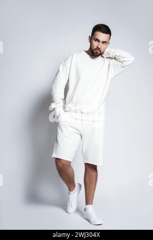 Hübscher Mann mit weißem Sweatshirt und Shorts Stockfoto