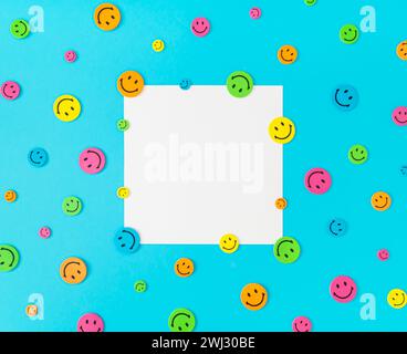 Farbenfrohe Musterkomposition mit Smiley-Aufklebern auf blauem Hintergrund. Minimales positives Denken und gute Stimmung. Stockfoto