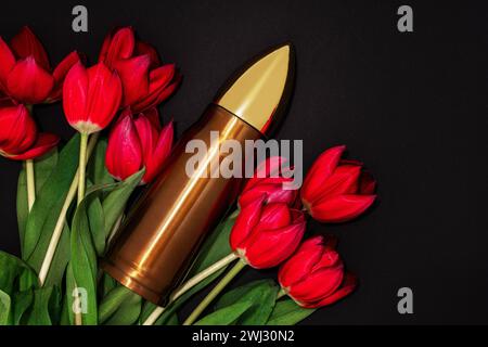 Pazifismus, Gewaltfreiheit oder Siegestag. Kugel und ein Haufen roter Tulpen. Stockfoto