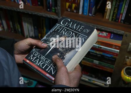 Srinagar, Indien. Februar 2024. 12. Februar 2024, Srinagar, Kashmir, Indien: A man hält das Buch Game of Thrones im Buchladen „Bestseller“ in Srinagar. Zum ersten Mal revolutioniert eine Buchhandlung in Kaschmir den Zugang zu Literatur, indem sie Bücher bei 500 Rupien anbietet. Am 12. Februar 2024 in Srinagar Kaschmir, Indien. (Foto von Firdous Nazir/Eyepix Group) Credit: SIPA USA/Alamy Live News Stockfoto