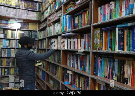 Srinagar, Kaschmir, Indien. Februar 2024. Ein Mann sucht Bücher aus dem Buchladen in Srinagar. Zum ersten Mal revolutioniert eine Buchhandlung in Kaschmir den Zugang zu Literatur, indem sie Bücher bei 500 Rupien anbietet. Am 12. Februar 2024 in Srinagar Kaschmir, Indien. (Kreditbild: © Firdous Nazir/OKULARIS via ZUMA Press Wire) NUR REDAKTIONELLE VERWENDUNG! Nicht für kommerzielle ZWECKE! Stockfoto