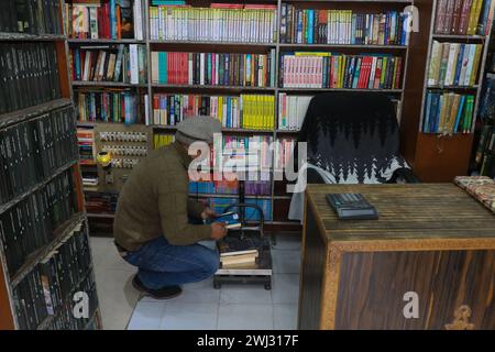 Srinagar, Kaschmir, Indien. Februar 2024. Ein Buchhändler aus Kaschmir passt Bücher in seinem Buchladen „Bestseller“ in Srinagar an. Zum ersten Mal revolutioniert eine Buchhandlung in Kaschmir den Zugang zu Literatur, indem sie Bücher bei 500 Rupien anbietet. Am 12. Februar 2024 in Srinagar Kaschmir, Indien. (Kreditbild: © Firdous Nazir/OKULARIS via ZUMA Press Wire) NUR REDAKTIONELLE VERWENDUNG! Nicht für kommerzielle ZWECKE! Stockfoto