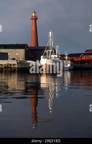 02.04.2023, Andoy, Nordland, NOR - Blick auf den Hafen mit dem Leuchtturm Andenes fyr. Andenes fyr, Andoy, aussen, Aussenaufnahme, Boote, Europa, europaeisch, Gebaeude, Gewaesser, Hafen, Hafenanlage, HF, Hochformat, Jahreszeit, Kueste, Kuestenlandschaft, Landschaft, Landschaftsaufnahme, Leuchtfeuer, Leuchtturm, Navigation, Navigationshilfe, niemand, Nordeuropa, Nordland, Norwegen, Norwegisch, Orientierungsfeuer, Richtfeuer, Schiffe, See, Seefeuer, Seezeichen, Signalanlage, Stadt, Wasser, Winter 230402D252ANDOY.JPG *** 02 04 2023, Andoy, Nordland, NOR Blick auf den Hafen mit dem Leuchtturm Ande Stockfoto