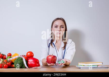 Lächelnd Ernährungsberaterin in Ihr Büro, Sie zeigt gesundes Gemüse und Früchte, Gesundheit und Diät Konzept. Stockfoto