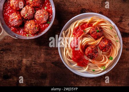 Fleischbällchen. Rindfleischbällchen, oben in einer Pfanne geschossen und mit einem Teller Spaghetti Stockfoto