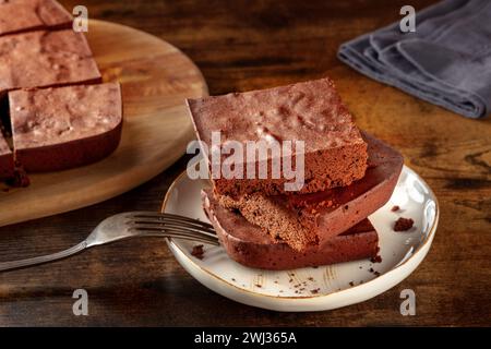 Schokoladenbrownie, einfacher Kaffeekuchen, auf einem dunklen rustikalen Holzhintergrund Stockfoto