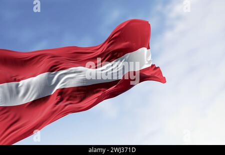 Nationalflagge der Republik Lettland winkt an einem klaren Tag im Wind Stockfoto