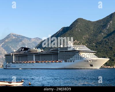 Perast, Montenegro - 03. august 2023: Großes Kreuzfahrtschiff fährt entlang der Bucht von Kotor in der Nähe der grünen Berge. Montenegro Stockfoto