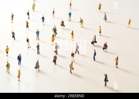 Spielzeugmenschen, Miniaturfiguren, die in der Öffentlichkeit Abstand halten. Soziale Distanzierung aufgrund der COVID-19-Ou Stockfoto