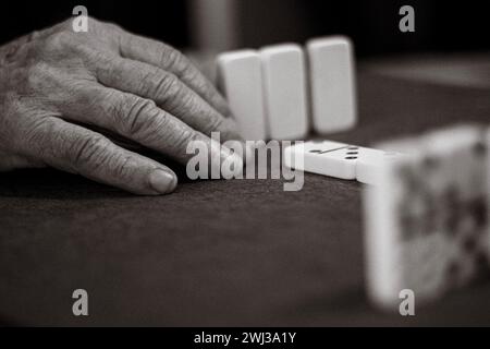 Nahaufnahme eines nicht erkennbaren älteren Menschen mit Falten und Adern, der ein Dominospiel spielt Stockfoto
