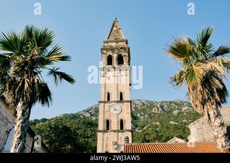 Glockenturm der Kirche St. Nikolaus vor dem Hintergrund der grünen Berge und des blauen Himmels. Perast, Montenegro Stockfoto